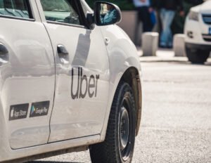 Car with the logo of the ride hailing company Uber in traffic.