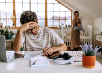 Mais-da-metade-dos-brasileiros-nao-sabem-organizar-o-proprio-dinheiro.jpg" alt="Homem analisando contas e documentos financeiros em casa, representando a dificuldade de como organizar o próprio dinheiro